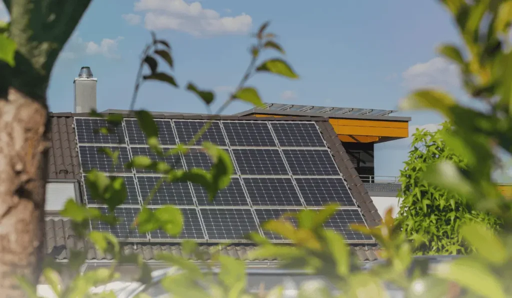 Solar panels on a rooftop generating renewable energy under a clear sky.